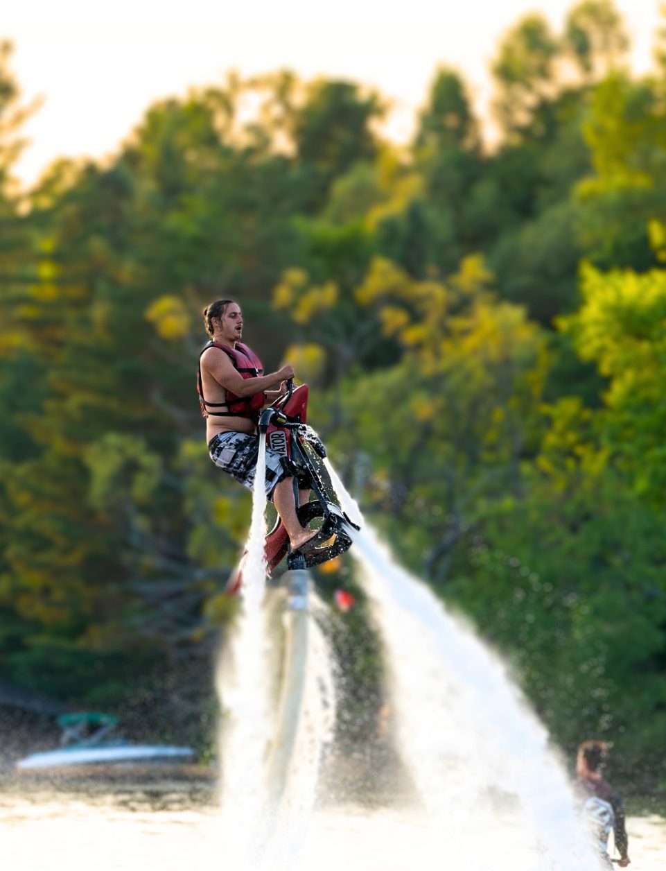 Rider on a hydro-flight Jetovator gliding over a Muskoka lake at golden hour